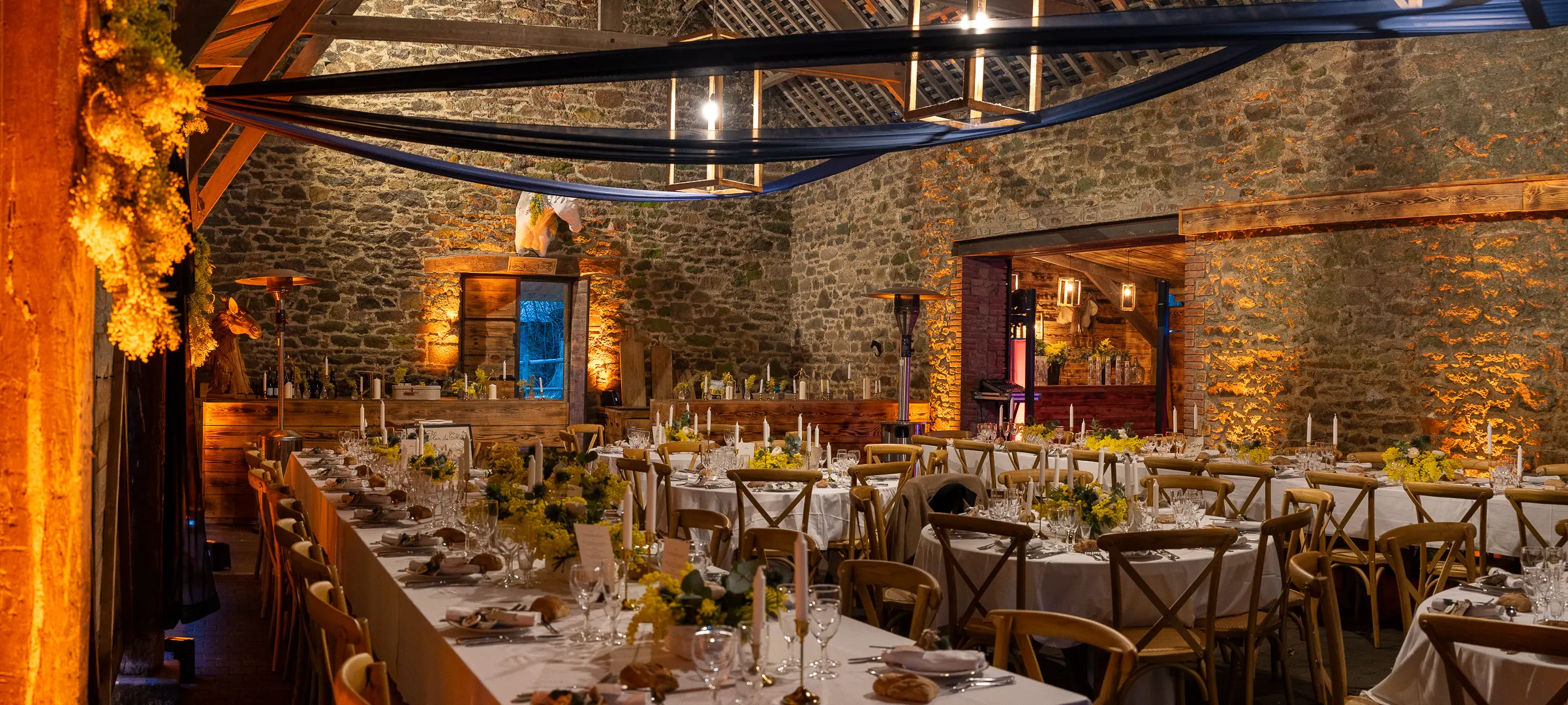 Éclairage architectural et ambiance lumineuse d'une salle de réception pour un mariage à Saint-Malo avec tables dressées et décoration élégante