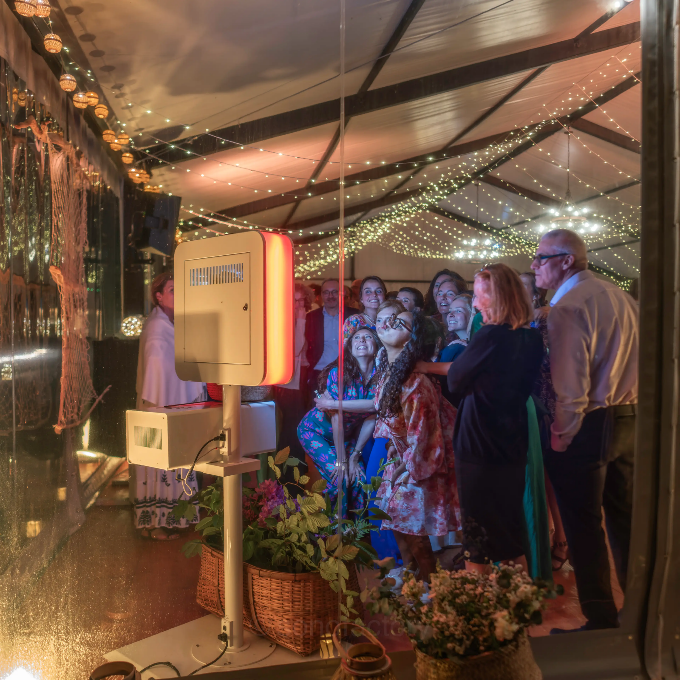 Invités s'amusant autour d'une borne photo photobooth pendant une soirée de mariage en Bretagne, avec sonorisation DJ professionnelle et effets visuels de Sonofactory