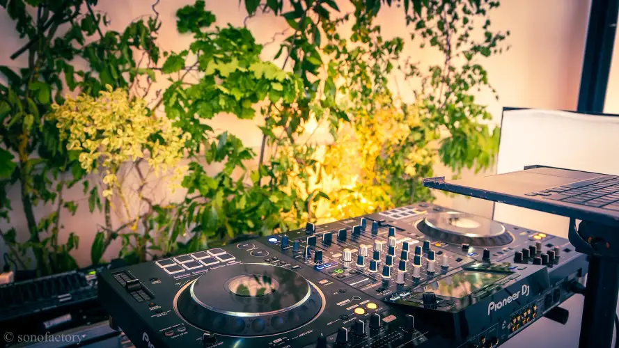 Installation de régie DJ professionnelle Pioneer sur un fond de décor végétal lors d'une réception haut de gamme en Ille-et-Vilaine par Sonofactory.